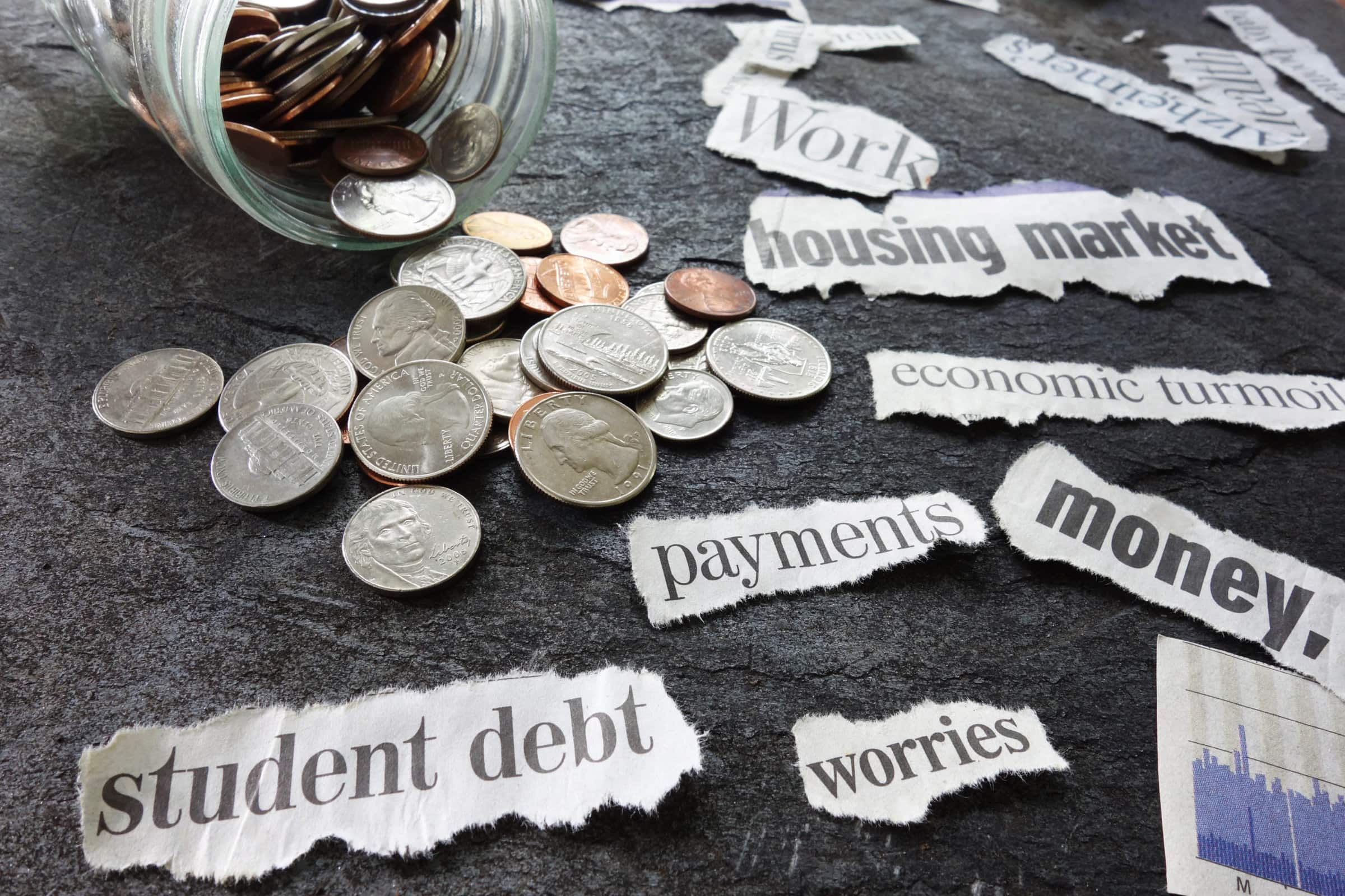 Assorted economy related newspaper headlines with coin jar