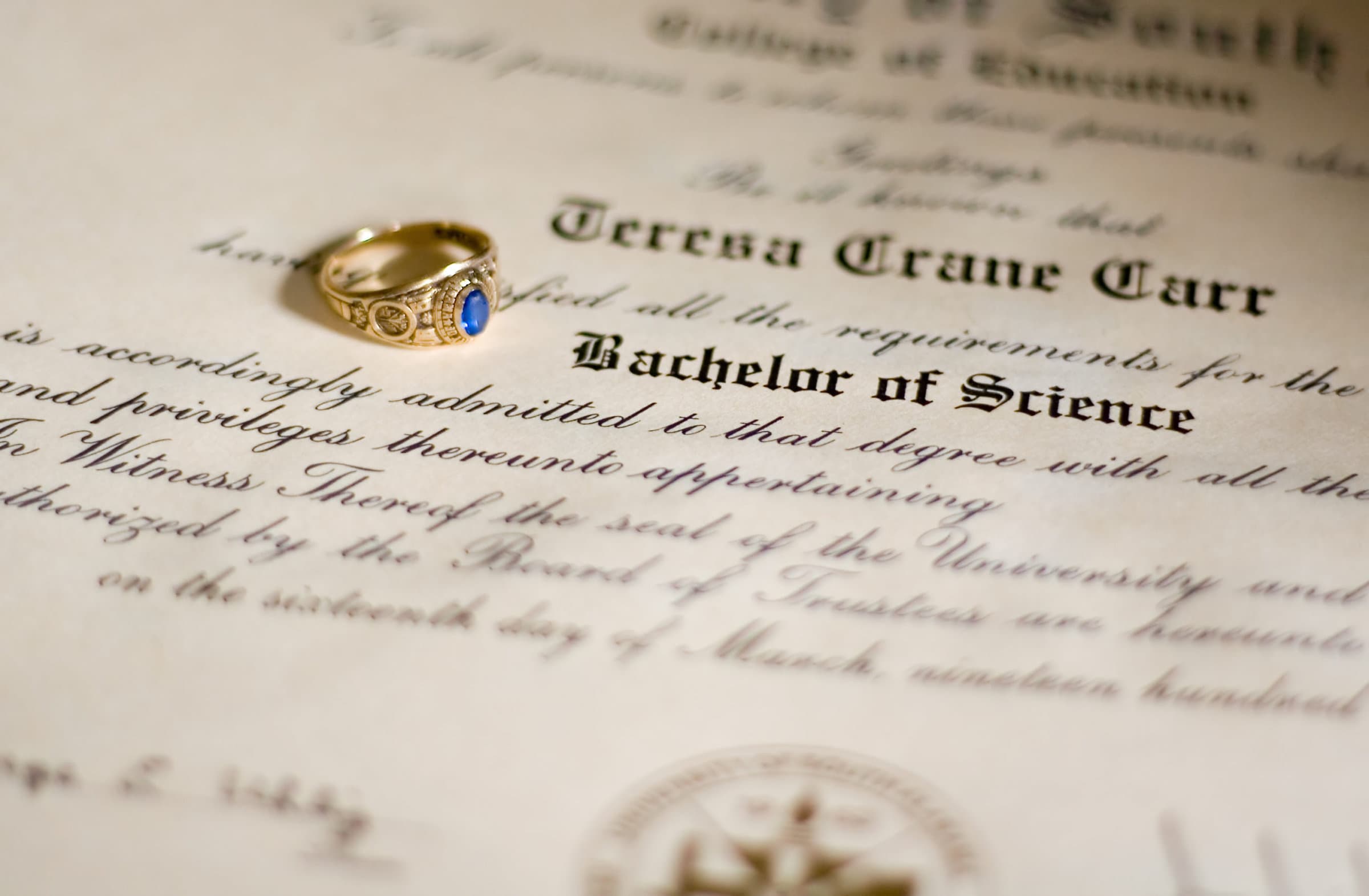 A close up view of a college diploma with a shallow depth of field, emphasizing the degree earned.