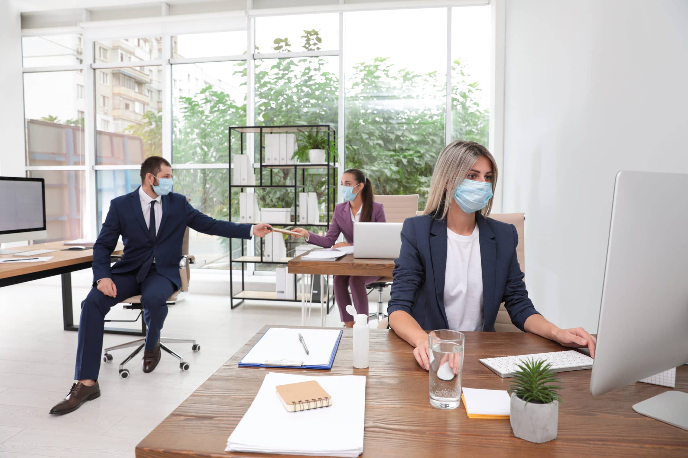 Office employees in respiratory masks at workplace Office employees in respiratory masks at workplace