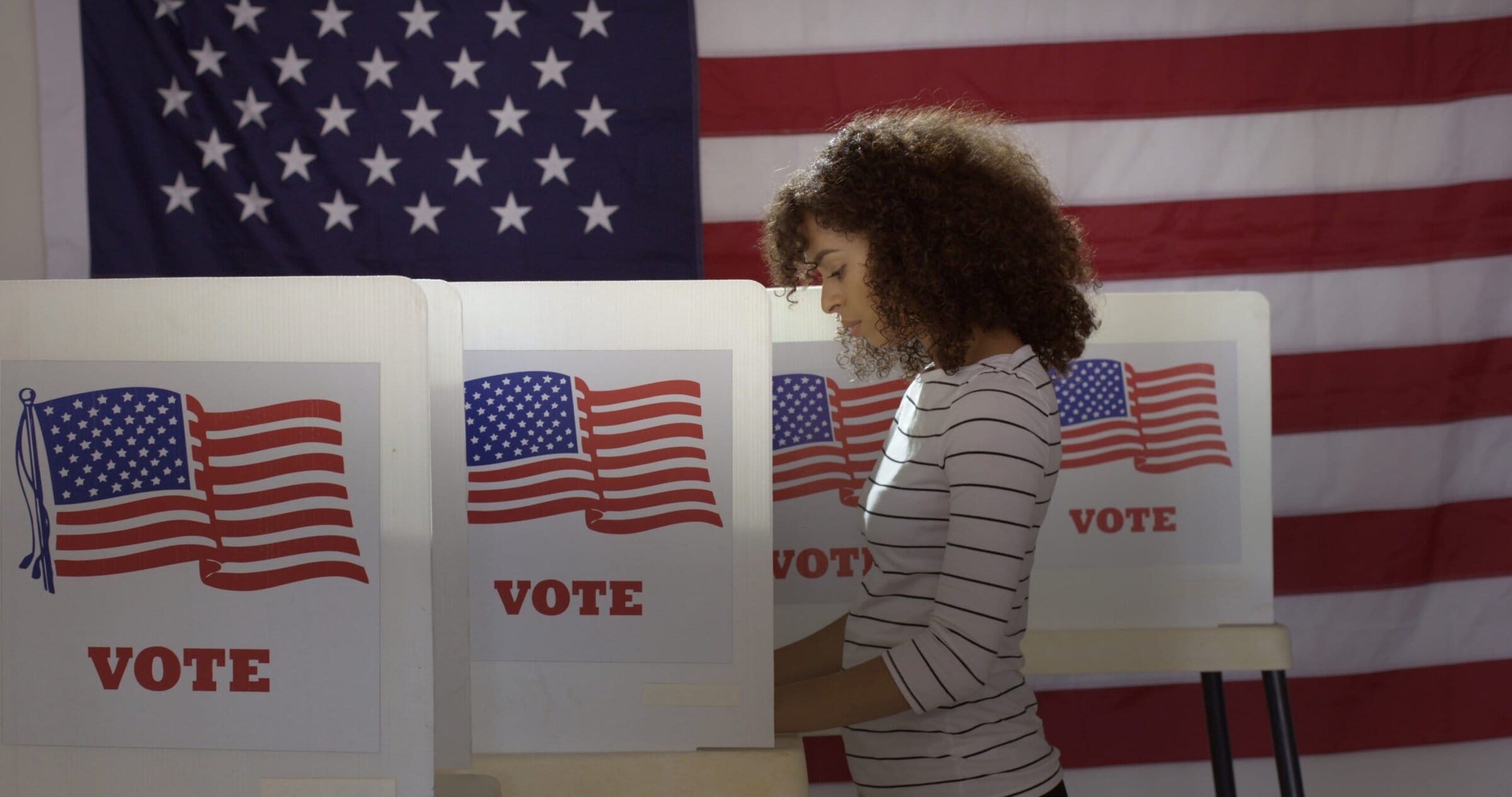 Profile, medium shot, young Hispanic woman in polling station, v Profile, medium shot, young Hispanic woman in polling station, v