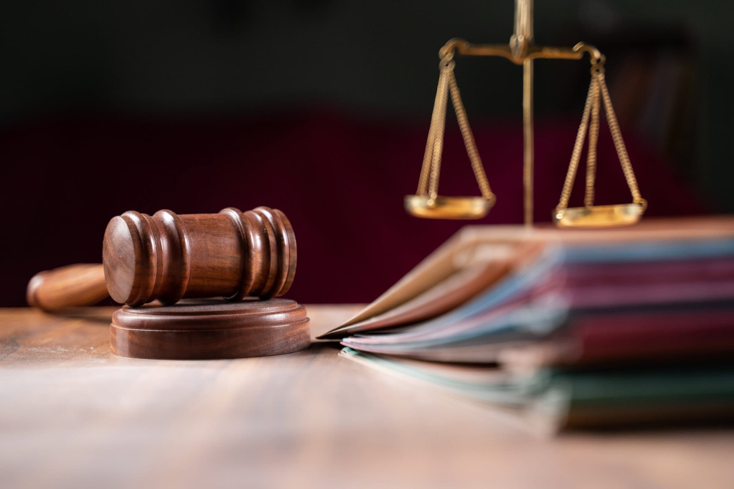 focus on hammer, group of files on judge table covered with dust - concept of pending old cases or work at judicial court focus on hammer, group of files on judge table covered with dust - concept of pending old cases or work at judicial court.