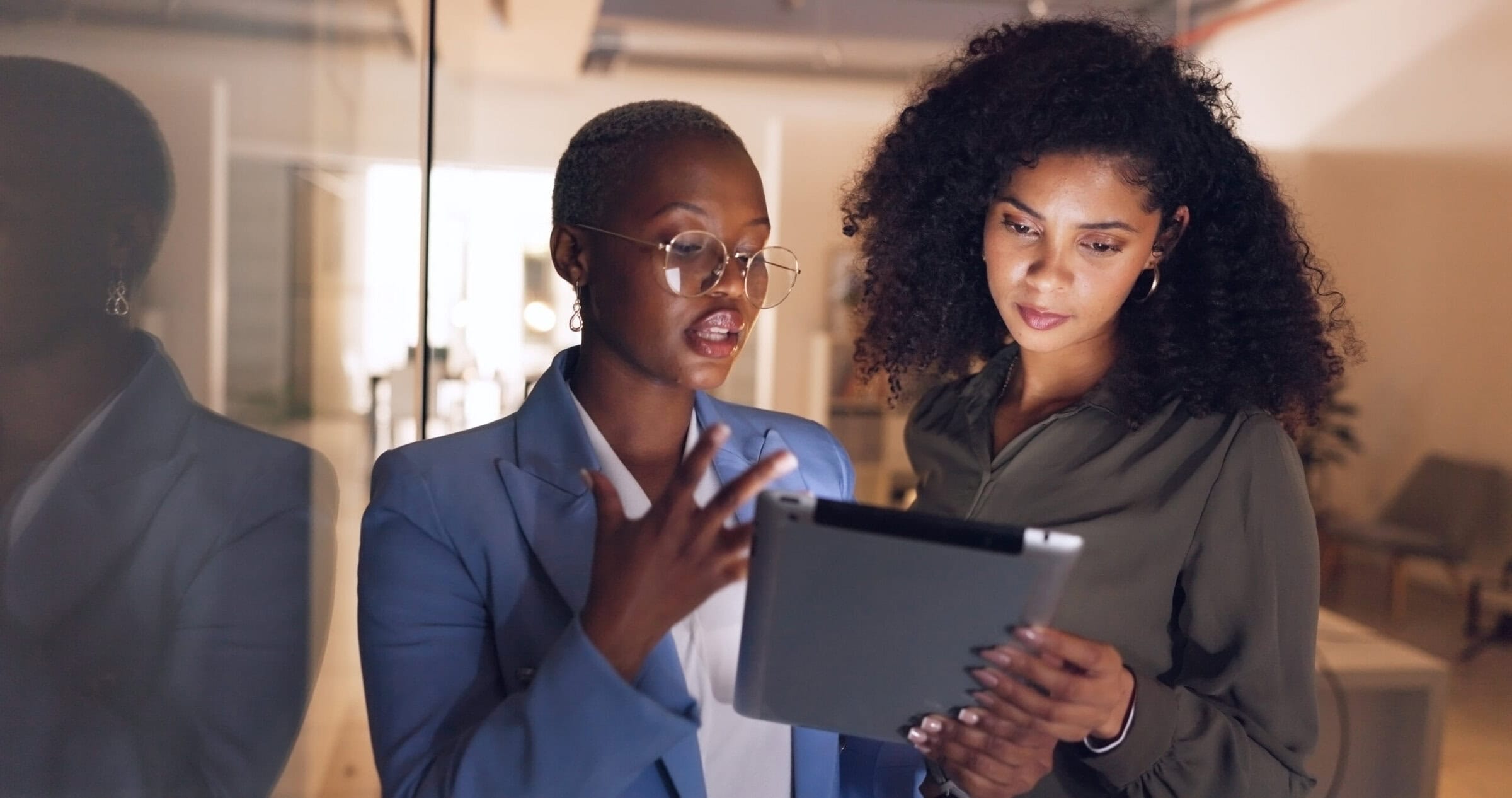 Black women, business and tablet in discussion or meeting for corporate strategy, planning or collaboration at office. African woman executive talking to employee on touchscreen technology at work.