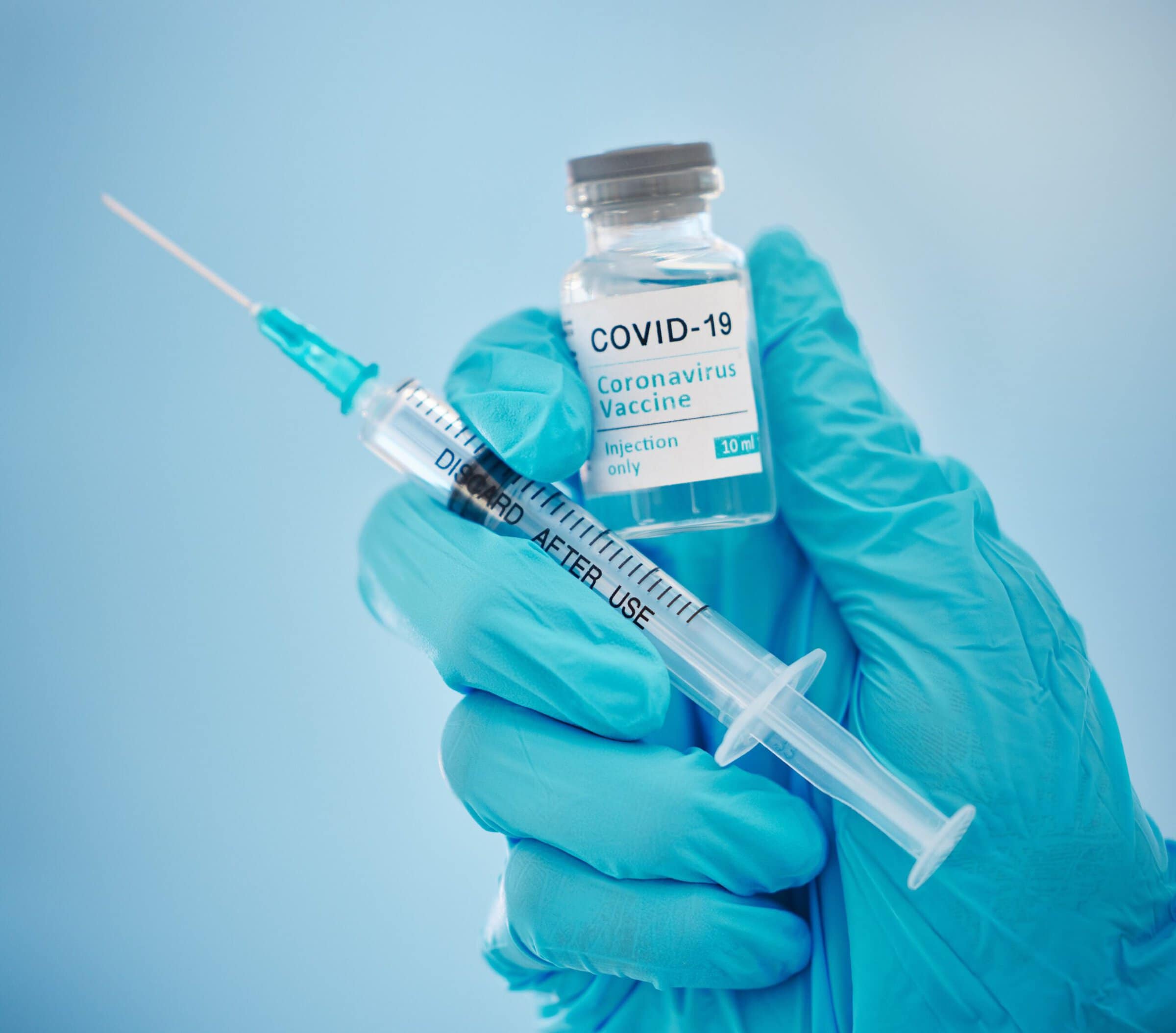 COVID vaccine Doctor, hands and covid vaccine for cure, healthcare or medical syringe medication to combat the virus. Hand of nurse holding corona virus sample with needle for vaccination from illness or disease