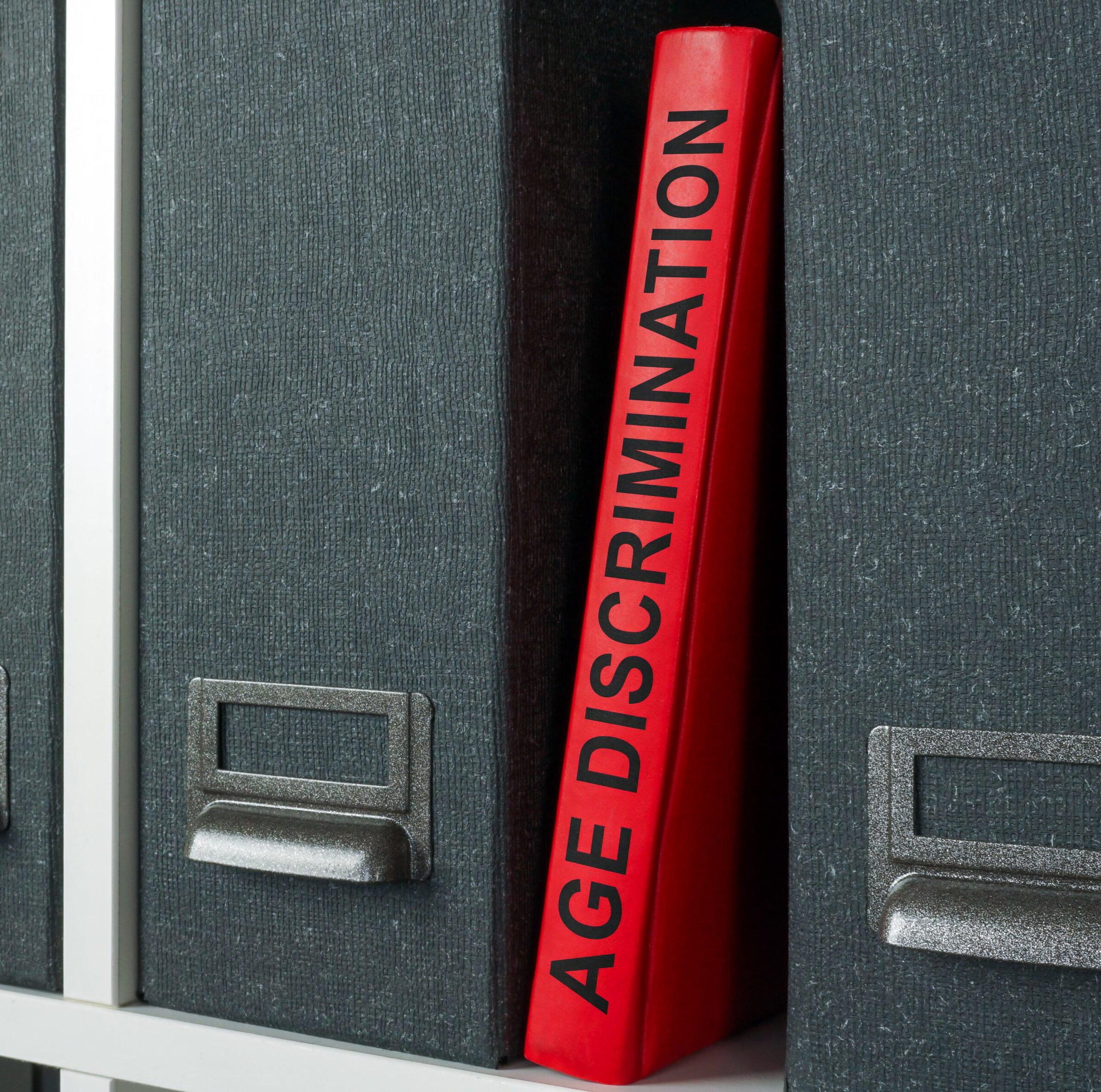 Office shelf with folders and age discrimination law book. Office shelf with folders and age discrimination law book.