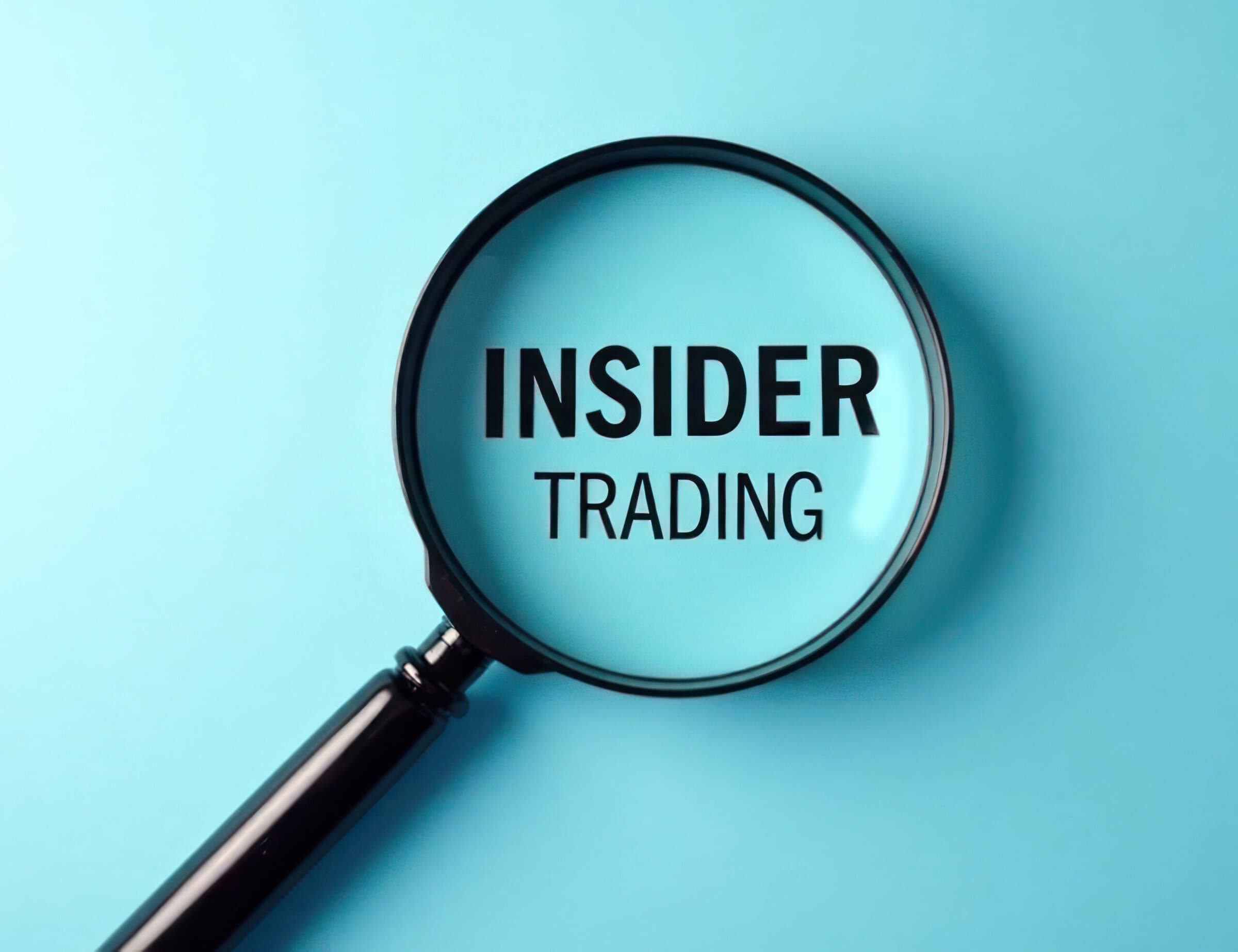 Magnifying glass focuses on insider trading, concept on light blue surface. Business analysis concept. Financial crime investigation. Revealing market manipulation. Examining investment strategies.